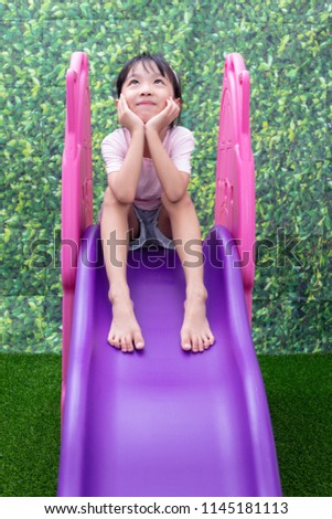 Asian Chinese Little Girl Playing on the slide at outdoor playground