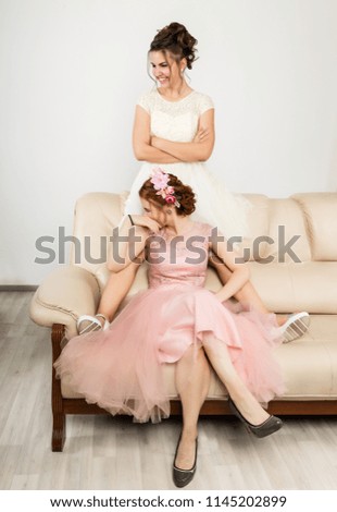 Two happy beautiful young women in elegant dresses, tender history