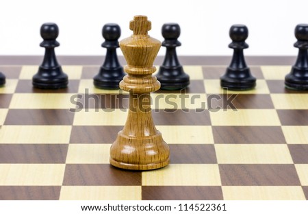 black wooden pawns against king, Only before the danger