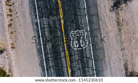 Bird’s eye view of painted on cracked asphalt roadside number sign of American landmark Route 66, aerial top view view of old retro sign on interstate asphalt highway of famous in USA