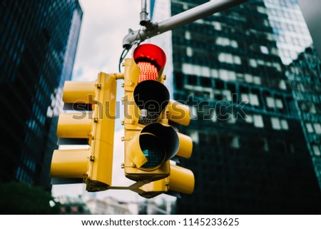 Equipment for regulating transport with lambs hanging in downtown in usa,yellow traffic lights controlling cars and supporting safety on crossways in megalopolis with high buildings and construction
