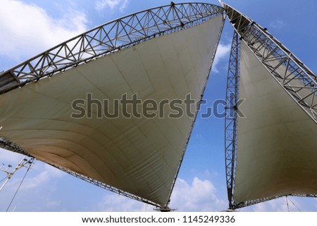 a triangular sail stands in the city park