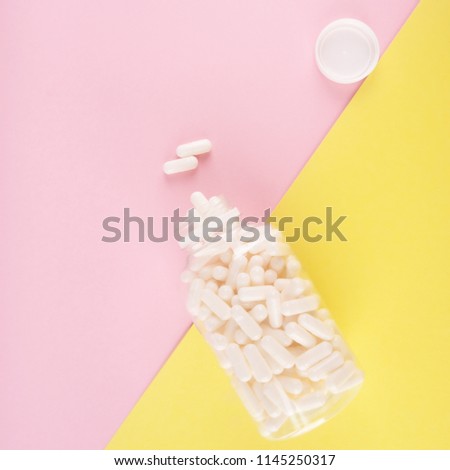 White pills isolated on pastel coloured background. Medication and prescription pills flat lay background