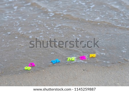 Plastic letters on sand
