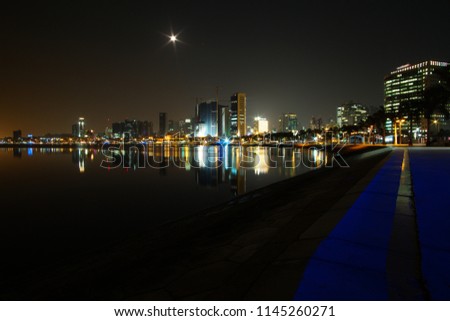 Long exposure night wide angle view of Marginal de Luanda with full moon and Mars moments after the beginning of lunar eclipse