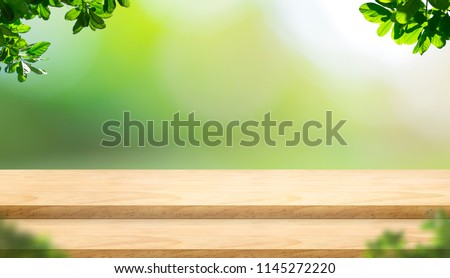 Empty step plank wood table top with blur tree in park with bokeh light background and leaves foreground,Mock up template for display of your design,Banner for advertise of product,panorama view.