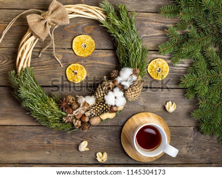 Christmas decoration, Christmas wreath, Christmas tree branches and cup of tea on vintage wood texture. New Year frame or Xmas Mockup. Rustic style. Royalty-Free Stock Photo #1145304173