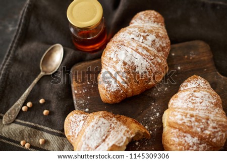 Freshly baked croissants on wooden Board on dark background