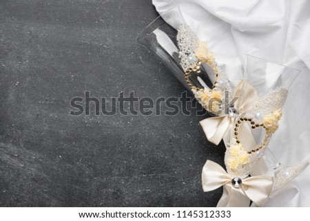 Black background with white fabric and wedding glasses, place for text