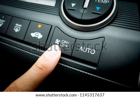Finger pressing on Power button on off switch of a Car air conditioning and heating system To turn on the Fan of the A/C inside the Car Royalty-Free Stock Photo #1145317637