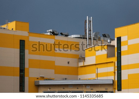 A clean yellow wall of the new shopping center building with communications without signage, advertising and banners
