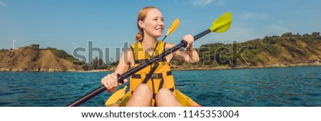 Smiling young woman kayaking on sea. Happy young woman canoeing in sea on a summer day BANNER, long format