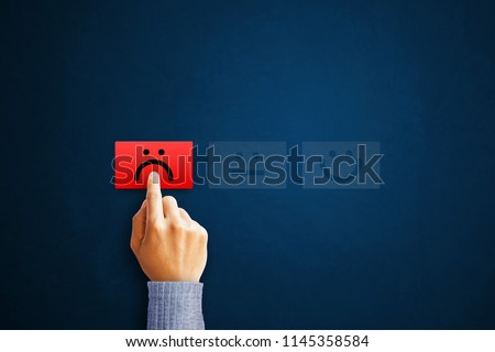Hand of client show a feedback with bad smile face card. Service rating, satisfaction concept Royalty-Free Stock Photo #1145358584