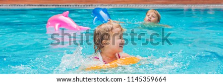 Pretty little girl swimming in outdoor pool and have a fun with inflatable circle BANNER, long format