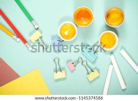 goods for creativity and school lie on a bright background near school black board
