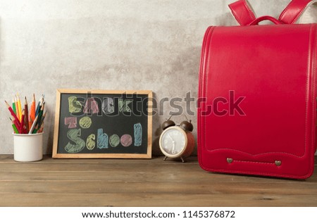 Group of school supplies and books over with red schoolbag on wooden background with copyspace. Back to school concept.