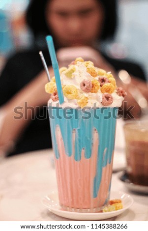 sweet drink with cereal on top and wip cream , blurry background , selective focus