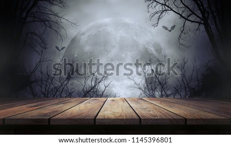 Old wood table and silhouette dead tree at night for Halloween background. Royalty-Free Stock Photo #1145396801