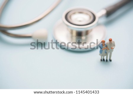 miniature figure senior couples  stand with stethoscope  on blue  background.health and relationship concept