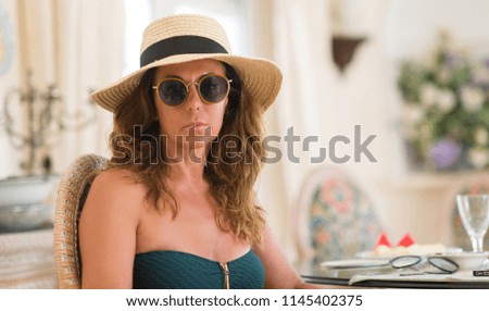 Middle age brunette woman wearing sunglasses with a confident expression on smart face thinking serious