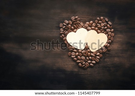 Wooden cartoon heart put middle coffee bean heart shape,on wooden table.texture background.