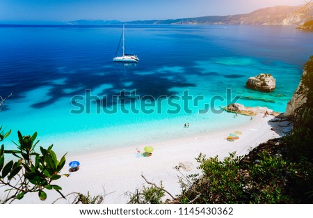 Fteri beach, Cephalonia Kefalonia, Greece. White catamaran yacht in clear blue sea water. Tourists on sandy beach near azure lagoon Royalty-Free Stock Photo #1145430362