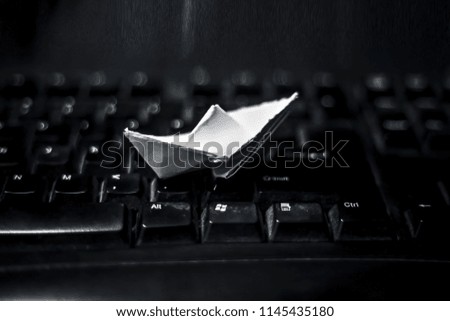 Paper boat on keyboard concept of