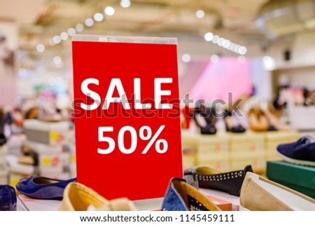 SALE 50% red poster in  Shoe store, blurred background