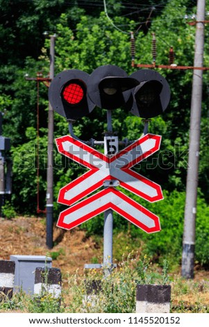 Railroad crossing sign with blinking red lights of semaphore