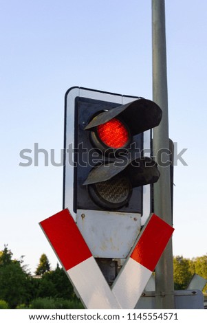 railroad crossing with red light in allgau south germany summer evening