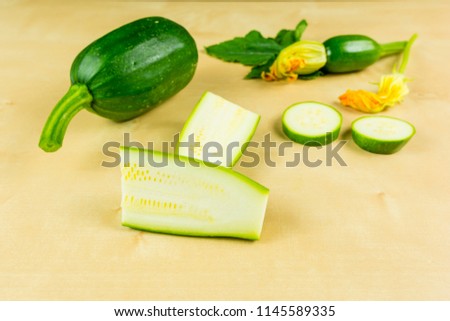 Presentation of cut young green zucchini on a wooden board.