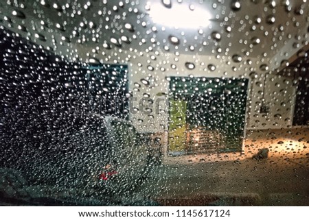 shoot picture inside through the mirror for image of water drop on car 's glass window