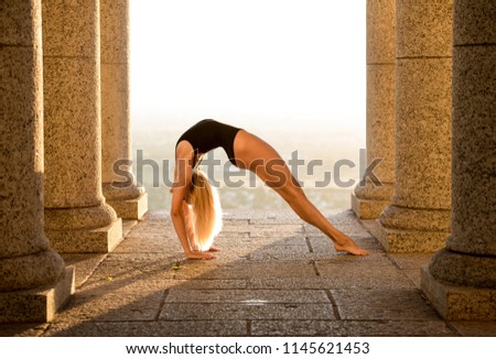 Young gymnast stretches on the sunrise