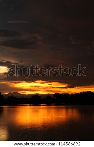 Beautiful sunset on the water and falling rain in nakhonsawan province, Thailand.