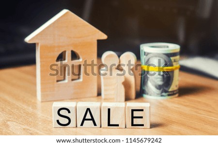 concept of real estate. model of the house, family, dollars and the inscription "sale" on wooden blocks. family moves and sells a house or apartment