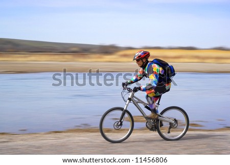 Speed motion mountain biker beside river