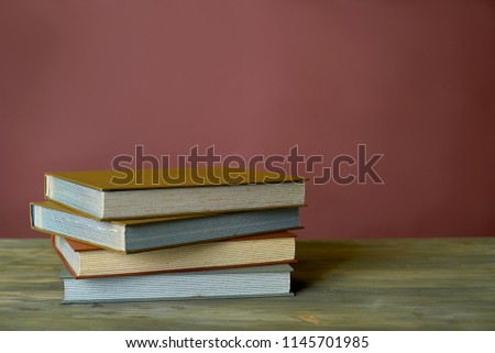 Four stamp albums books bunch on wooden table and bordeaux background