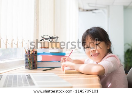Girl sitting on her desk in the room.