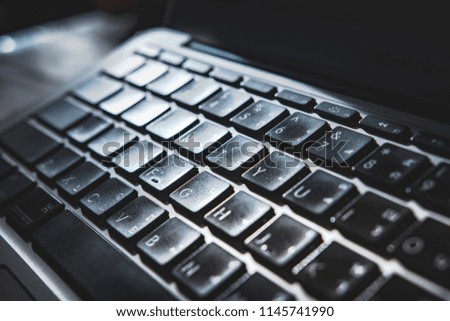 Macro view of black keyboard buttons against back light