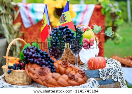 Moldova Independence Day celebrated on August 27. Elements of the Moldovan national identity: tricolor flag, grape vines, grapevine, wine barrel and baked bread. Conceptual picture for banners.