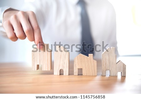 Hand of businessman choosing house model, Planning buy Real Estate.