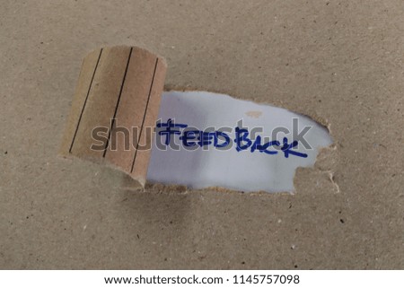 The word feedback appearing behind torn brown paper.

