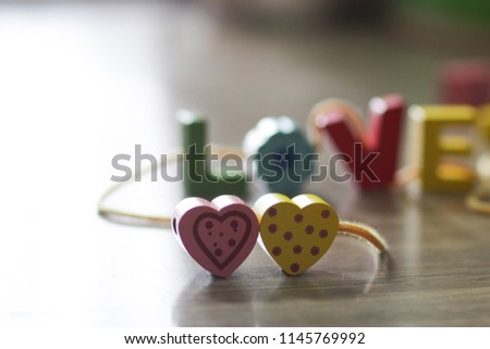 LOVE letter with heart. A word of love tied up on strings with wooden background. Valentine's Day, selective focus.