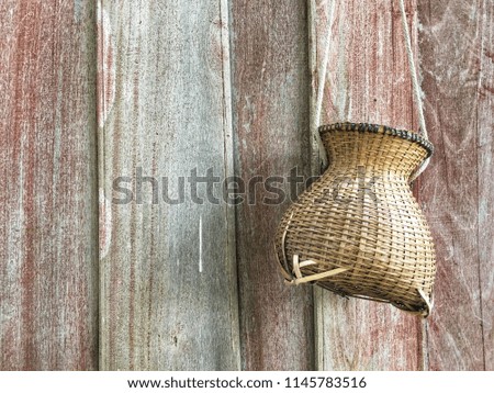 Wicker basket for fisherman used to keep fish on the wooden wall