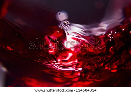 Red wine on a black background , abstract splashing. Royalty-Free Stock Photo #114584314