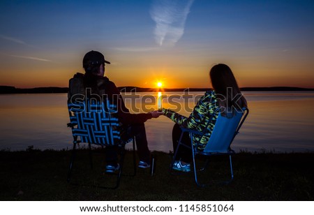 happy loving couple enjoying the beautiful sunset at the sea, romantic mood, silhouettes at sunset