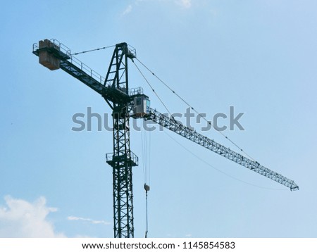Crane. Construction crane against blue sky. Construction site.