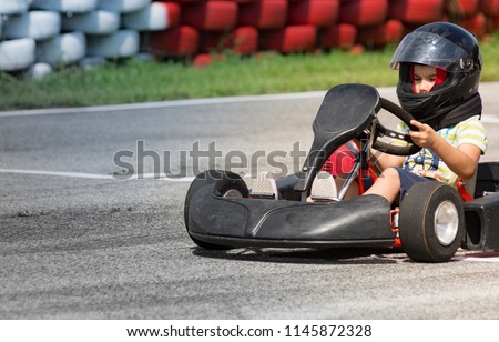 eight year old boy drives go-kart Royalty-Free Stock Photo #1145872328