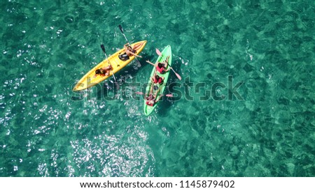 Aerial drone photo of colourful sport canoes as shot from above in turquoise clear sea