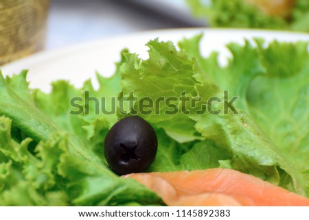 olives with salmon in lettuce leaves